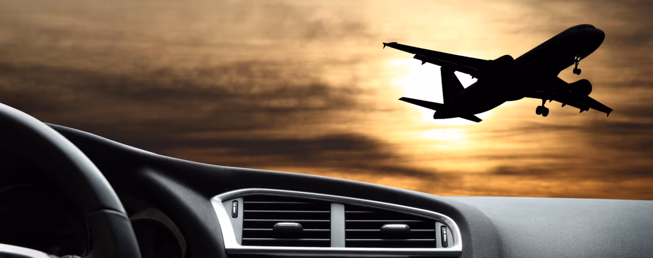 Sicht auf startendes Flugzeug durch Windschutzscheibe eines Mietautos