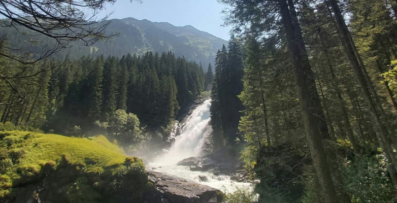 Krimmler Wasserfälle in Österreich zwischen Bäumen im Sonnenschein